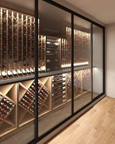 there is a wine cellar with many bottles on the wall and behind it are glass doors that open to let in plenty of light