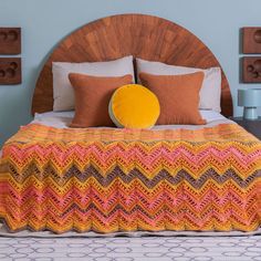 a bed with a wooden headboard and pillows on top of it in a bedroom