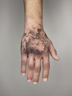 a man's hand with clouds on it