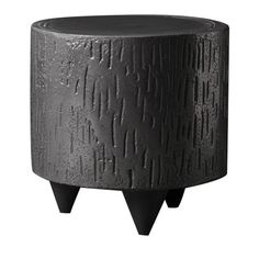 a black planter sitting on top of a wooden stand with metal spikes in it