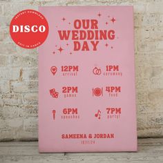 a pink poster with the words our wedding day written in red on it next to a brick wall