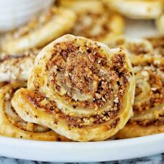 cinnamon rolls on a white plate with other pastries in the backgroung