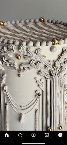 an ornate white cabinet with gold knobs