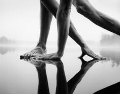 the legs and feet of a person reflected in water