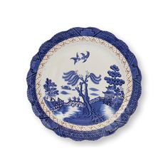 a blue and white plate with an image of a tree on the side, birds flying over it