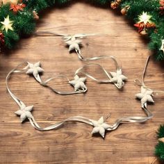 a wooden table topped with christmas decorations and wreaths on top of it's sides