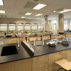 an empty lab with lots of desks and chairs in it's center area