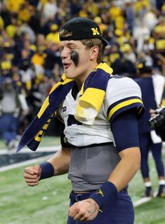 a football player with his face painted in the colors of michigan