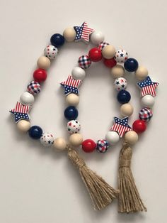 the patriotic beaded bracelet is decorated with red, white and blue beads that are attached to tassels