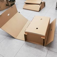 several cardboard boxes sitting on the floor with one open and another closed in front of them