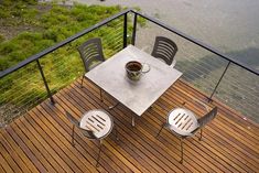 a table with two chairs and a cup on top of it sitting on a deck