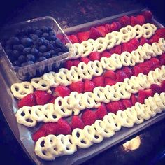 an american flag dessert with strawberries and blueberries in the shape of pretzels