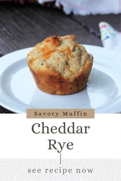 a white plate topped with a muffin on top of a wooden table