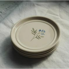 a stack of white plates with blue flowers on them