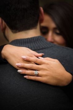 a man and woman embracing each other with their hands wrapped around them