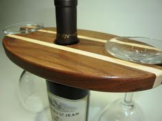 there is a wine glass and bottle on top of a wooden shelf with two glasses