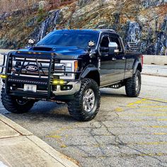 a black pickup truck parked in front of a mountain