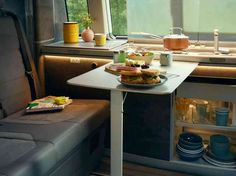 a table with food on it in the back of a vehicle next to a window