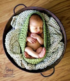 a newborn baby wrapped in a green blanket