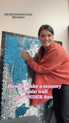 a woman standing in front of a large piece of art that says how to make a sensory wall under $ 20