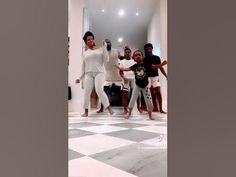 a group of people dancing on a checkered floor