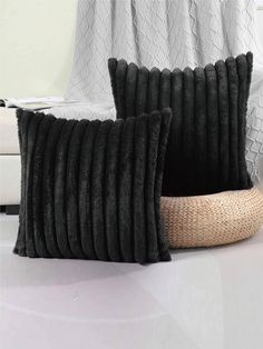 two black pillows sitting next to each other on a white floor in front of a window