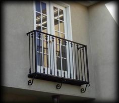 a balcony with wrought iron railing and windows