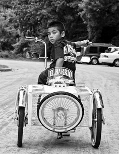 a young boy riding on the back of an old fashioned motorcycle with a side car