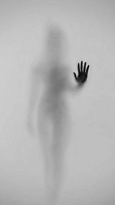 the shadow of a person's hand is shown in front of a white wall