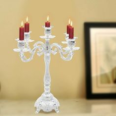 a glass candelabra with three candles on it