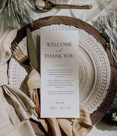 a welcome card on a plate with silverware and napkins