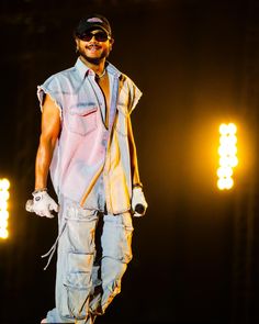 a man standing on top of a stage with his hands in his pockets and smiling