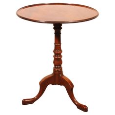 a small wooden table with two legs and a round top on an isolated white background