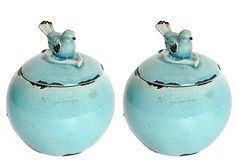 two blue vases with birds sitting on top of each other in front of a gray wall