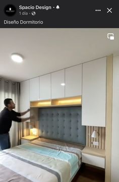 a man standing in the middle of a bedroom next to a bed