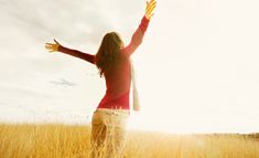 a woman is standing in the middle of a field with her arms spread wide open