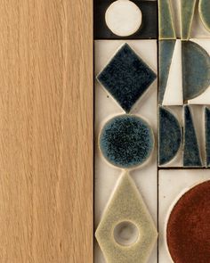 several different shapes and sizes of tiles on a wooden surface, including one with an oval in the middle