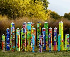 many colorful poles are lined up in the grass