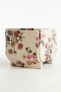 an upholstered chair with floral print on the seat and back, sitting against a white background