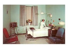 a woman standing in a hospital room next to a bed and chair with flowers on it