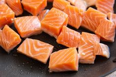 raw salmon being cooked in a frying pan