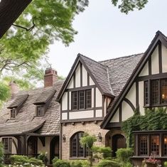 a large house with lots of windows and ivy growing on the side of it's roof