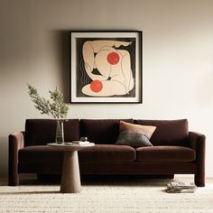 a living room with a couch, coffee table and painting on the wall