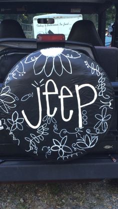 a jeep with the word jeep painted on it's tire cover in white lettering