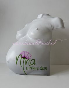 a white plastic breast statue with a pink flower on it's side and the words ma 21 marz 2015 written in cursive