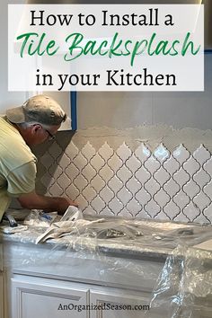 a man installing tile backsplash in his kitchen