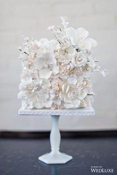 a white wedding cake with flowers on top