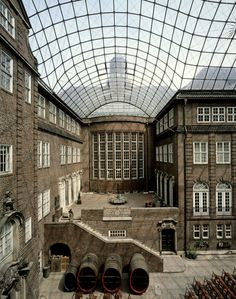 the inside of an old building with lots of windows and pipes in front of it