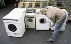 a man kneeling down next to a washing machine