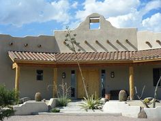 an adobe style house with cactus and succulents